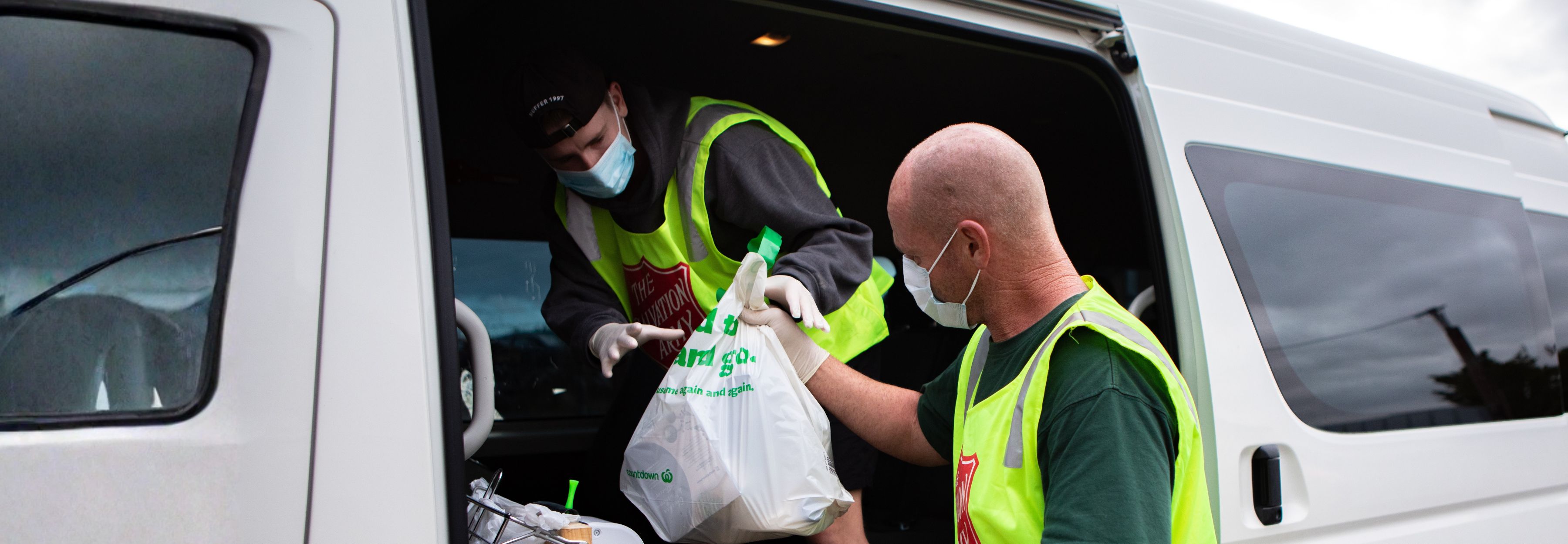 Salvation Army volunteers handing out food during COVID-19 pandemic.